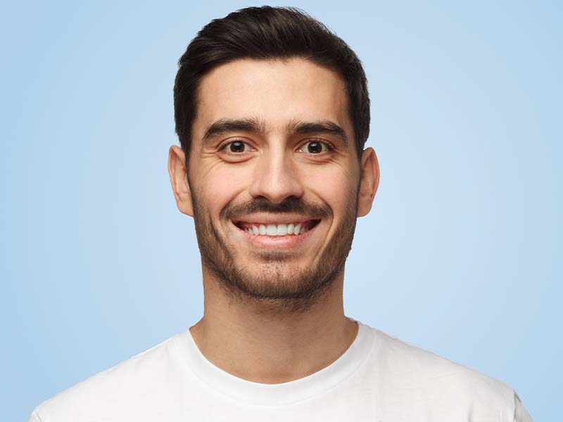 Man smiling against a light blue background