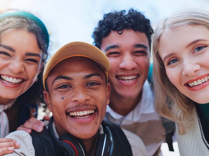 Four friends smiling together for a selfie