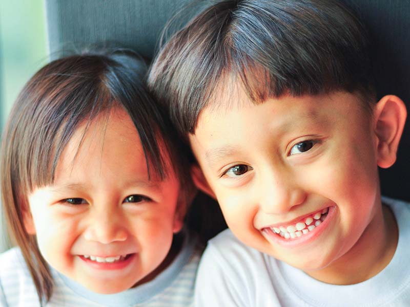 Two young children smiling together