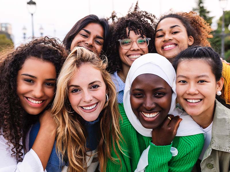 Diverse group of women smiling together outdoors