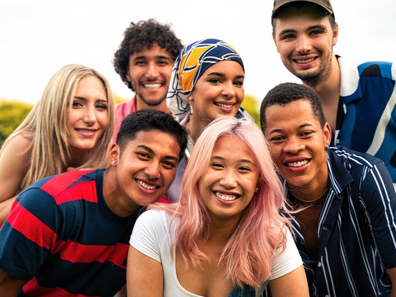 Diverse group of teenagers smiling together outdoors