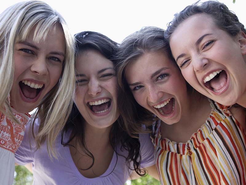 Four women laughing together outdoors