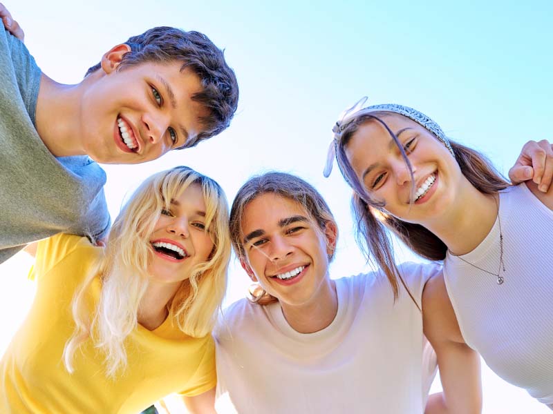 Group of teenage friends smiling together outdoors