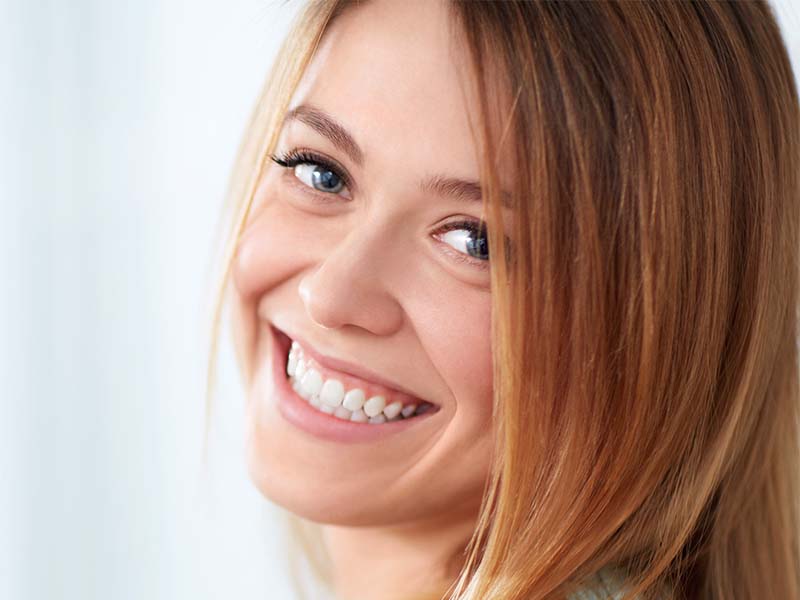 Woman with light brown hair smiling indoors