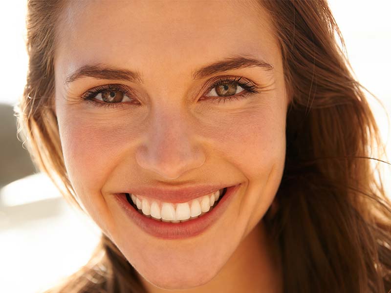Close-up portrait of a woman smiling at the beach